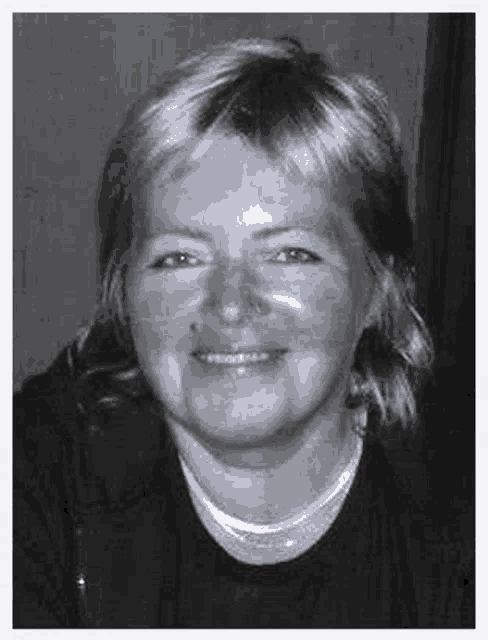 a black and white photo of a woman smiling .