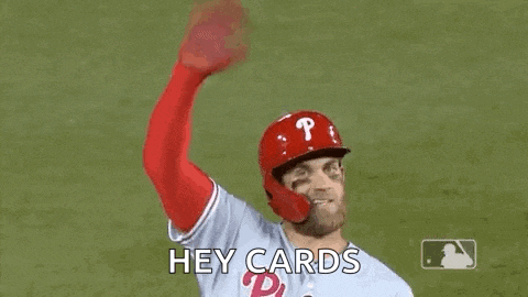 a baseball player is waving his hand in the air while wearing a helmet and gloves .
