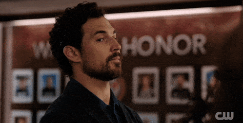 a man is standing in front of a wall that says honor