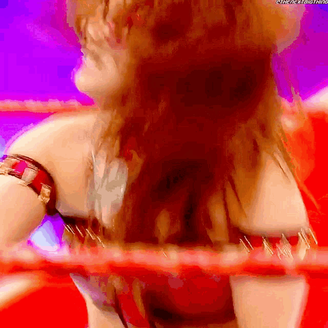 a woman in a red top is standing in a wrestling ring with the hashtag #thenextbig thing
