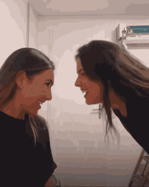 two women are looking at each other and smiling at each other