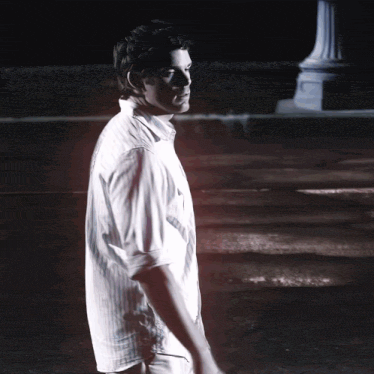 a man in a white shirt stands in front of a sign that says tda