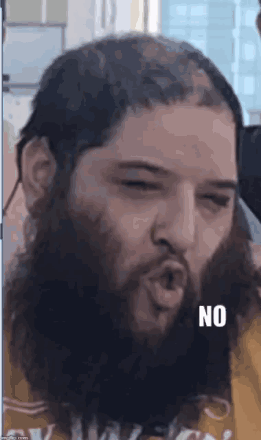 a man with a beard is making a face and the word no is on the bottom
