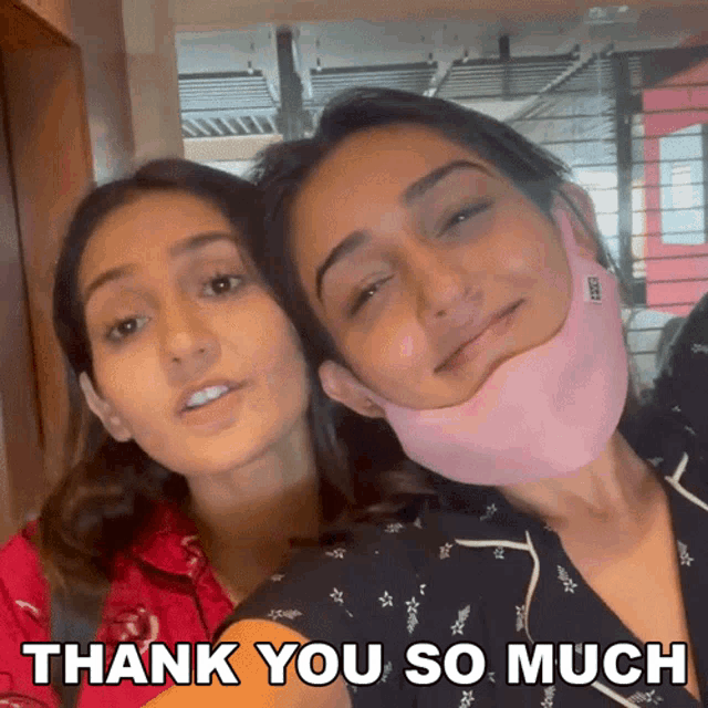 two women wearing face masks are posing for a picture with the words thank you so much below them