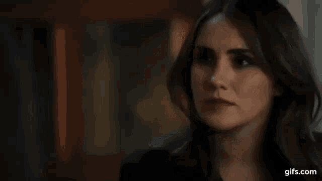 a close up of a woman 's face in a dark room .