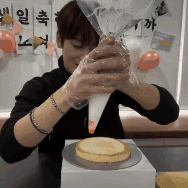 a person is decorating a cake in front of a sign with chinese writing