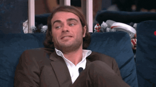 a man in a suit is sitting on a couch with his legs crossed