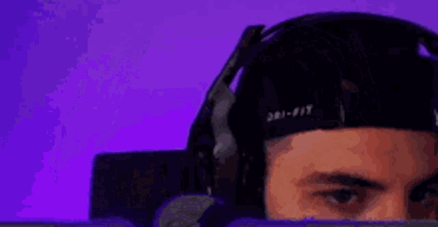 a close up of a man wearing headphones and a hat .
