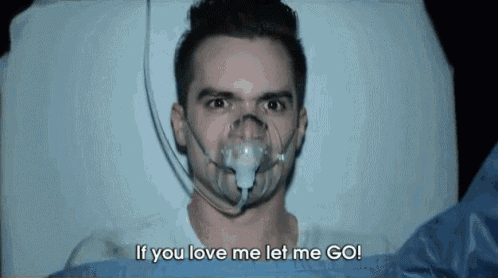 a man wearing an oxygen mask is laying in a hospital bed .