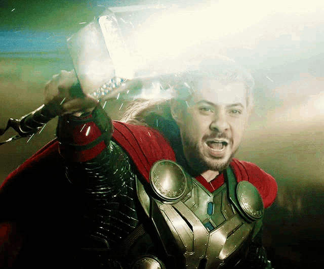 a man in a superhero costume is holding a hammer in his hand