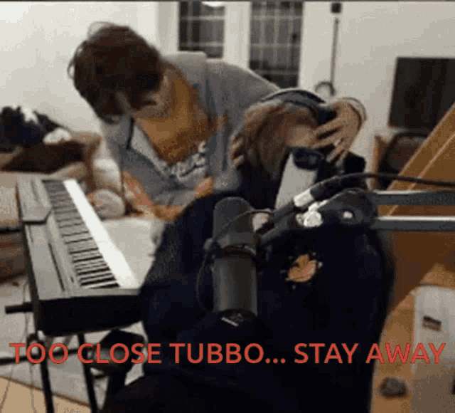 a person playing a piano with the words " too close tubbo ... stay away " in red
