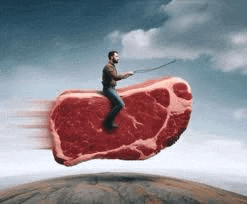 a man is riding a giant piece of meat in the air .