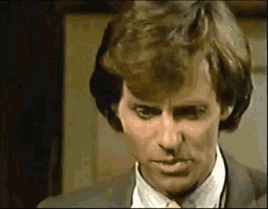 a man in a suit and white shirt is making a face .