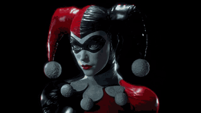 a statue of harley quinn is wearing a red and black costume