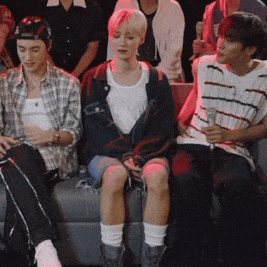 a group of people are sitting on a couch with one wearing a hat that says fox