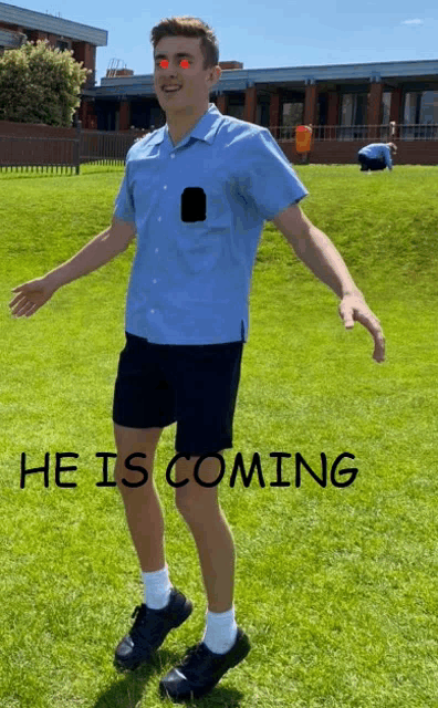 a man in a blue shirt and black shorts is standing in a field with the words he is coming behind him