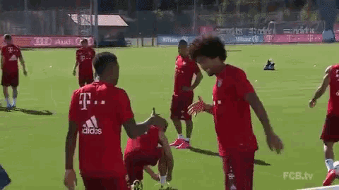 a group of soccer players are playing on a field and one of them is wearing an adidas shirt .