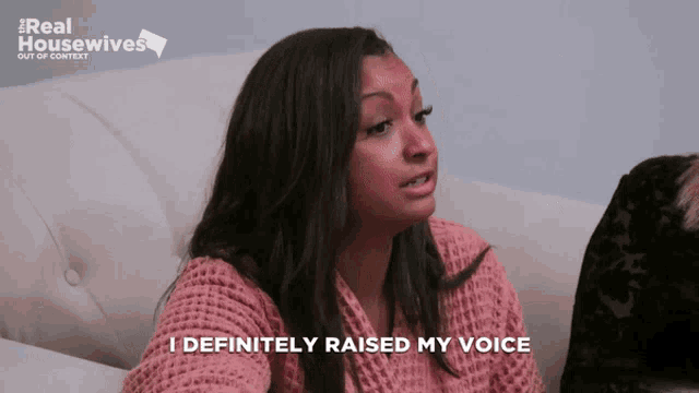 a woman sitting on a couch with the words i definitely raised my voice above her