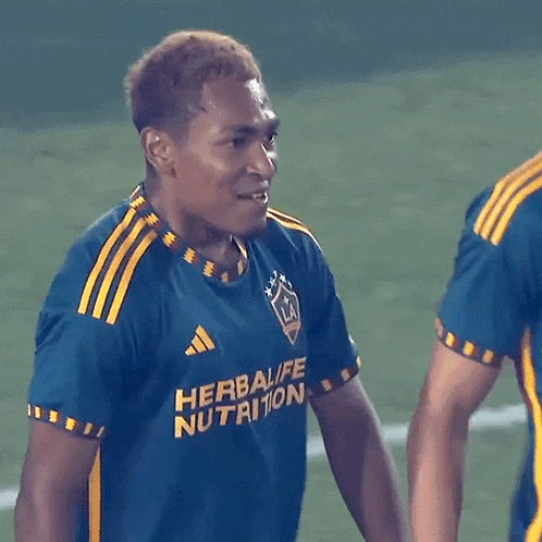 a soccer player wearing a blue and yellow shirt that says herbalife nutrition