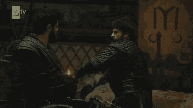 two men are fighting in front of a sign that says iyi on it