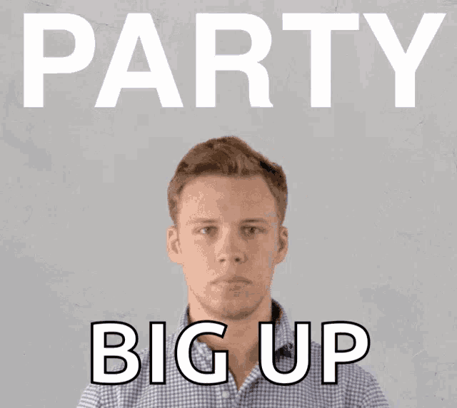 a man in a plaid shirt is blowing confetti in front of a sign that reads party big up