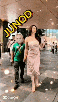 a man in a green shirt is standing next to a woman in a white dress with junod written on the bottom