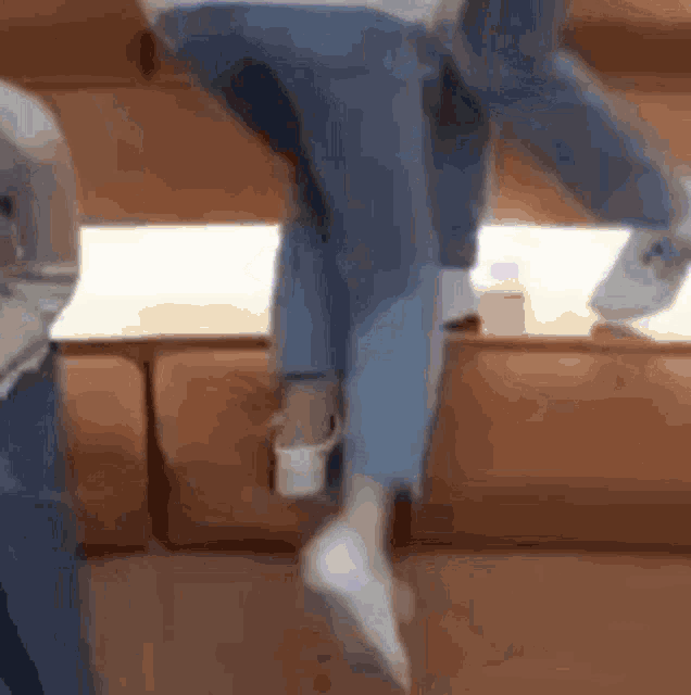 a person is standing on a couch with their feet up in the air .