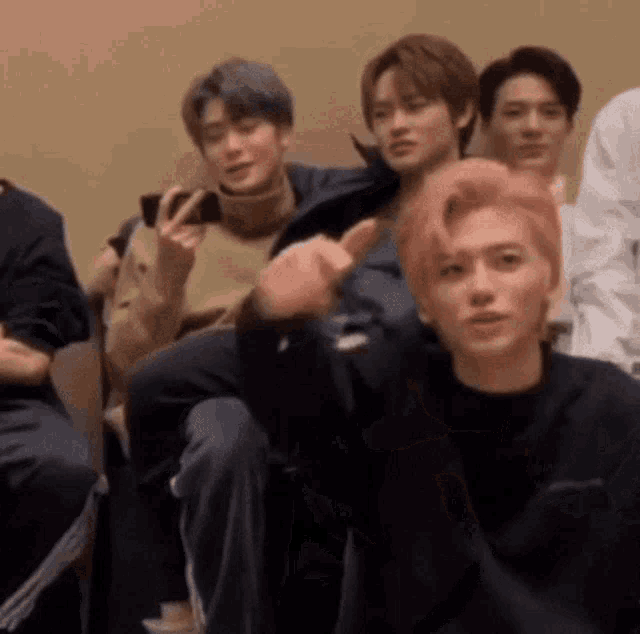 a group of young men are sitting in a room .
