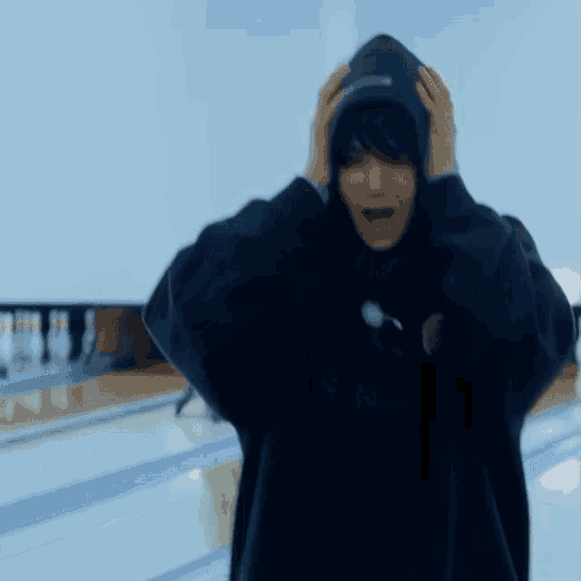 a person wearing a black hoodie is standing in a bowling alley .