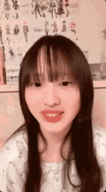 a girl with long hair and bangs is smiling and looking at the camera