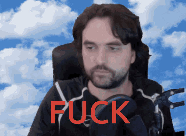 a man with a beard is sitting in front of a cloudy sky and the word fuck is written in red