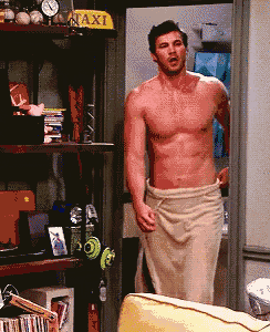 a shirtless man with a towel around his waist is standing in front of a taxi sign