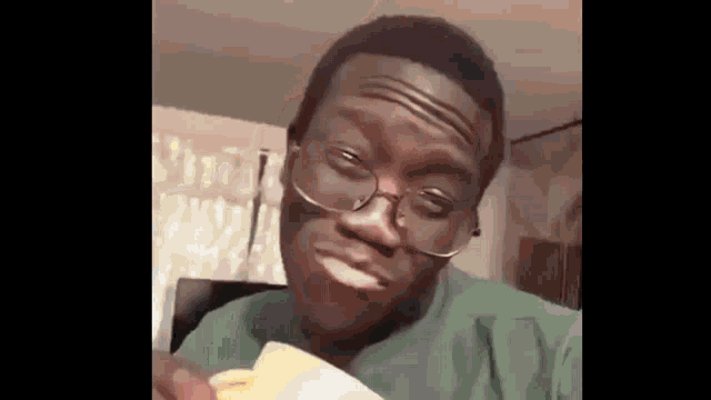 a young man wearing glasses is eating french fries .