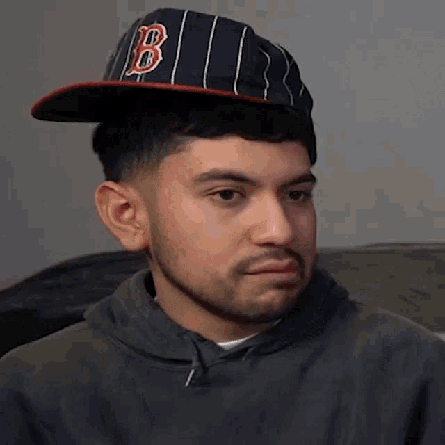 a man wearing a hat that says b on it