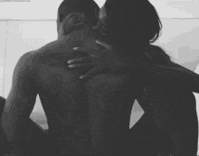 a black and white photo of a man and woman kissing
