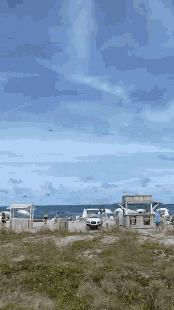 a white suv is parked on a beach near the ocean .