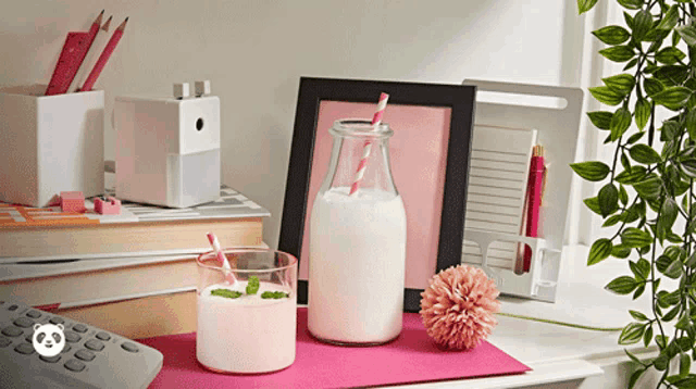 a bottle of milk sits on a table next to a cup of milk