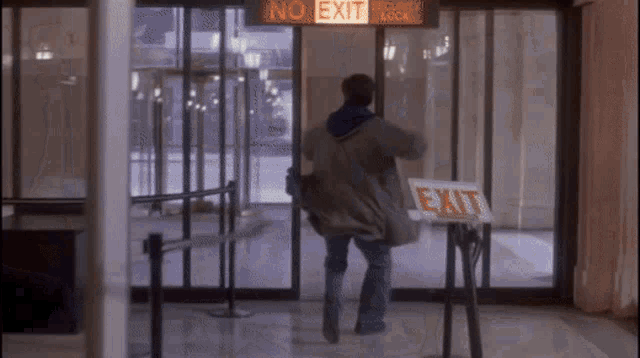 a man is walking through a security check with an exit sign in front of him