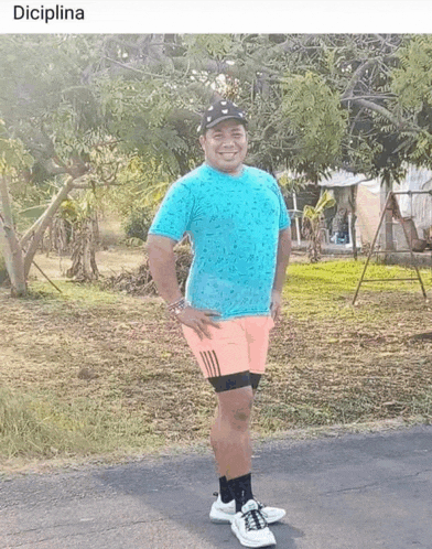 a man in a blue shirt and pink shorts is standing in a field with the word disciplina written below him