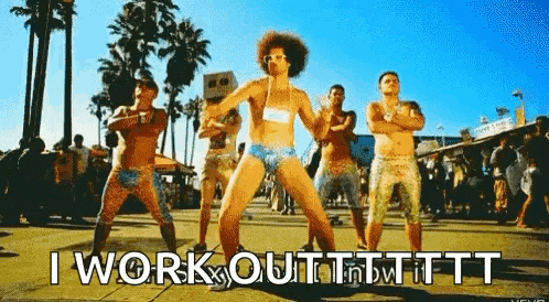 a group of men are dancing in front of palm trees and the words `` i work out '' are written on the ground .