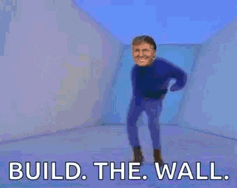 a man in a blue shirt is standing next to a group of toy soldiers and says `` build the wall '' .