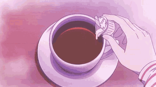 a person pouring sugar into a cup of coffee .