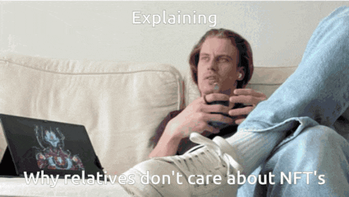 a man sitting on a couch with a laptop explaining why relatives don t care about nfts