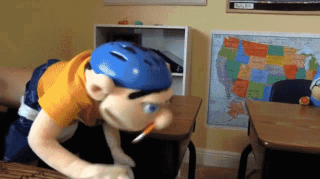 a map of the united states hangs on a wall behind a puppet