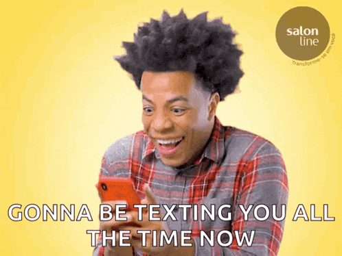 a man in a plaid shirt is smiling while looking at a cell phone with the words gonna be texting you all the time now