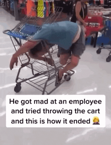 a man is laying in a shopping cart in a store
