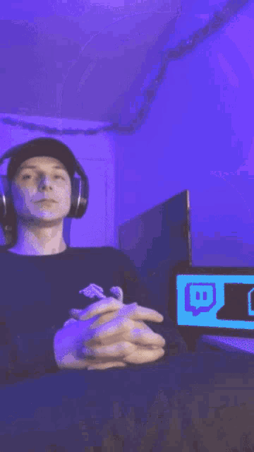 a man wearing headphones and a black sweatshirt with the letter x on it