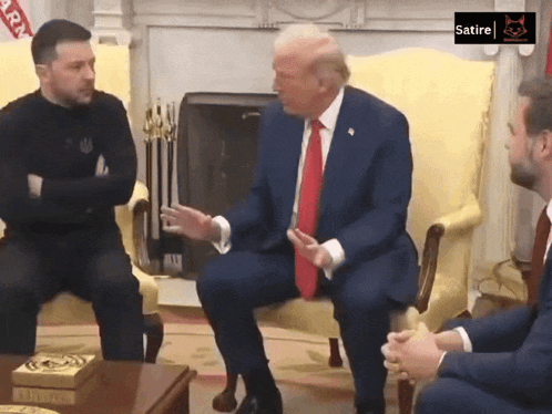 a man in a suit and tie is sitting in a chair with another man