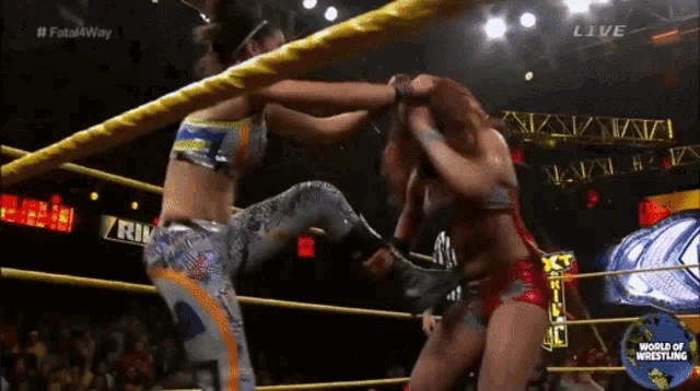 two women are wrestling in a ring with the words world of wrestling on the screen