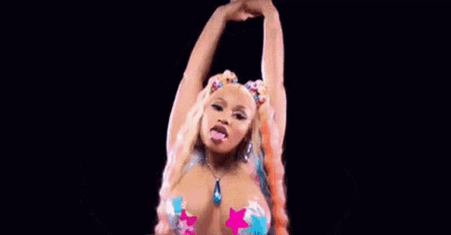 nicki minaj is wearing a very revealing outfit with a lot of stickers on her chest .